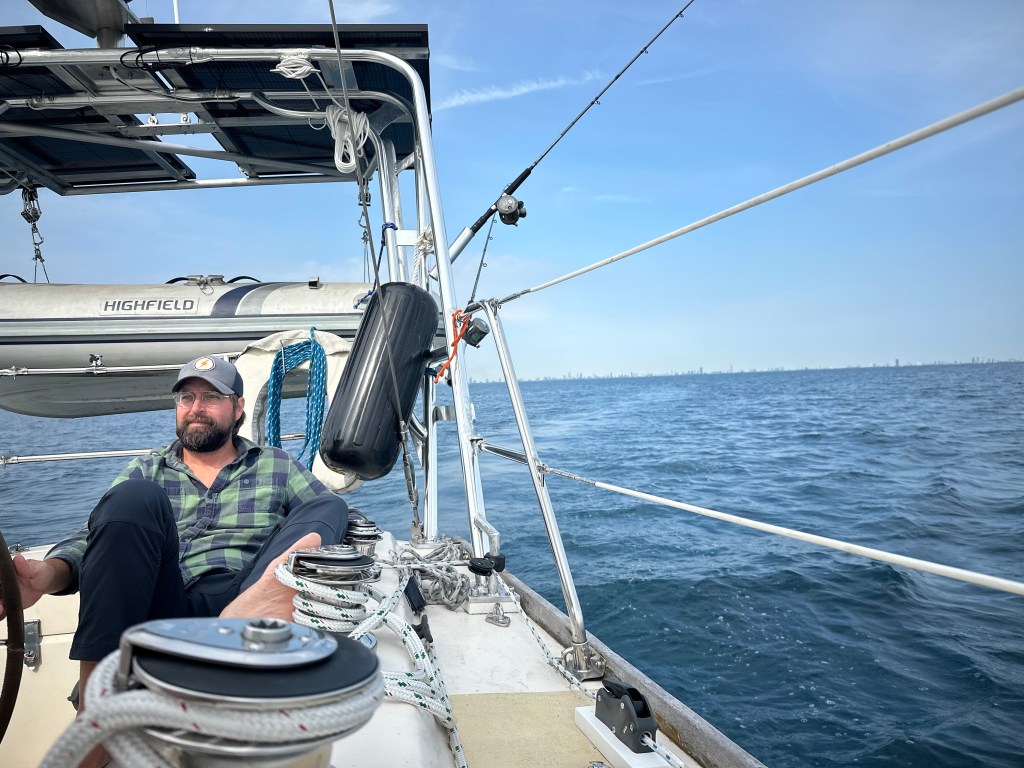 Eric drives the boat, the solar panels atop the arch behind him.